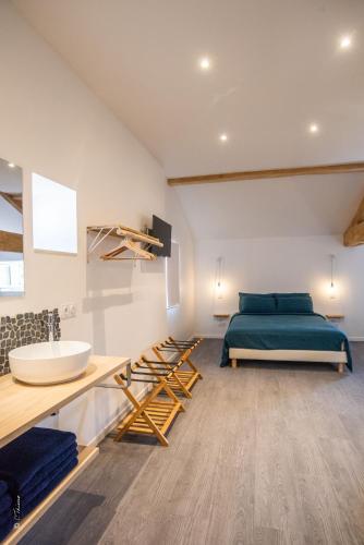 a bedroom with a bed and a sink at LA DOLOREANNE in Saint-Didier-sur-Chalaronne