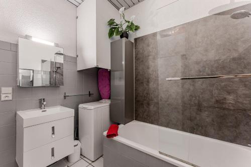 a white bathroom with a toilet and a sink at La Palmeraie 300m plage, calme in Arcachon