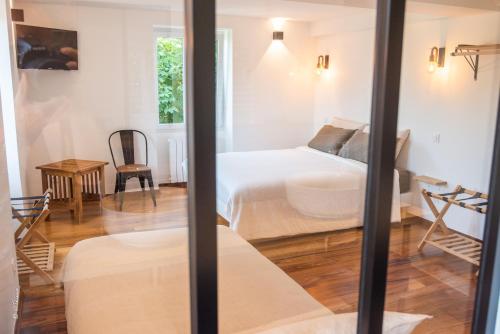 a bedroom with two beds and a table at LA DOLOREANNE in Saint-Didier-sur-Chalaronne