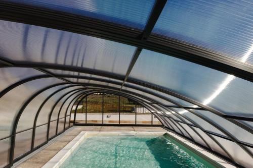 an indoor swimming pool in a building with a glass ceiling at Villa Olivieri B&B Wellness House in Viterbo