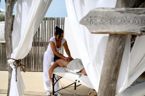 a woman in a white dress sitting in a chair at Lodge Sainte Helene Adult only in Saintes-Maries-de-la-Mer