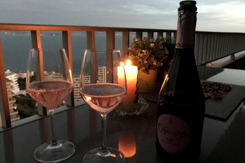 trois verres à vin sur une table avec une bouteille de vin dans l'établissement Helios grand studio terrasse panoramique magique, à Ajaccio