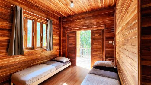 a room with two beds in a wooden cabin at Baan Bhuwann Forest Chalet in Koh Phangan