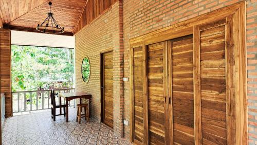 a wooden sliding door in a room with a table at Baan Bhuwann Forest Chalet in Koh Phangan