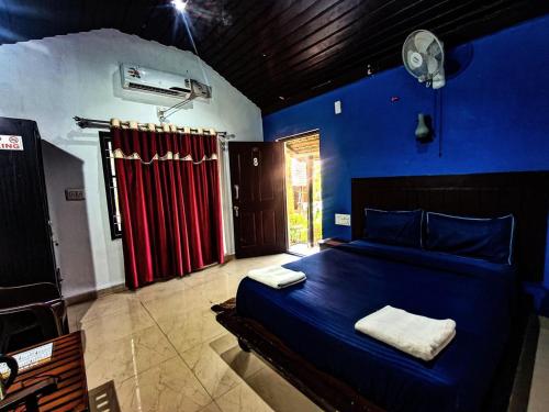 a bedroom with a bed in a blue room at Twin Cottages Resort Coorg in Madikeri