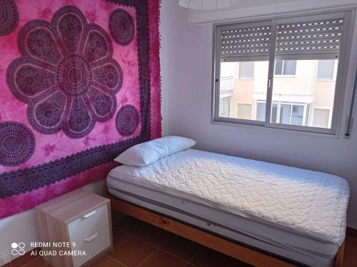 - un petit lit dans une chambre avec un mur rose dans l'établissement La Dorada Solo Familias Serviplaya!!!, à Playa de Xeraco