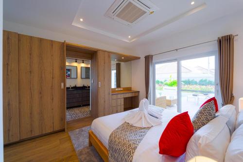 Una habitación de hotel con una cama con almohadas rojas. en Brand-New Modern 3-Bedroom Villa - MB20, en Hua Hin