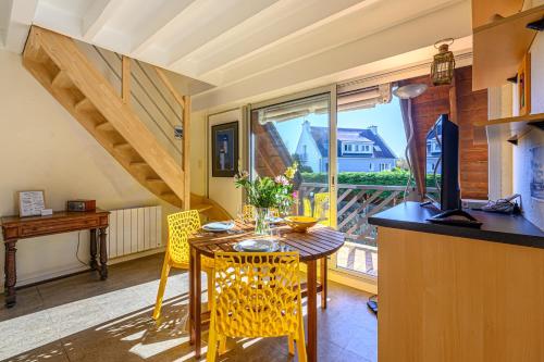 une salle à manger avec une table et des chaises et une fenêtre dans l'établissement Le Golfe Bleu - Appt près de la plage, à Locmariaquer