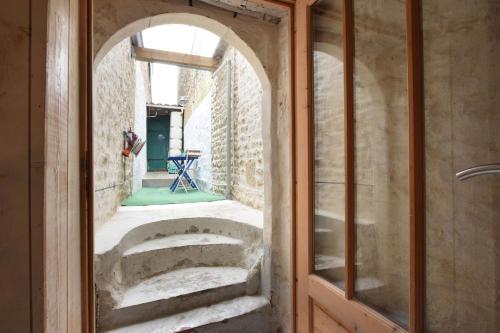 une voûte dans une chambre avec une porte en verre dans l'établissement Maison de pays coeur de village, à Sainte-Marie de Ré