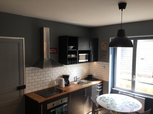 - une cuisine avec un comptoir, un évier et une table dans l'établissement Résidence Molière M4, à Soissons