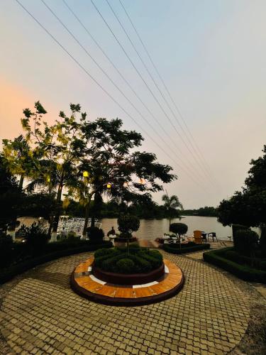 a stone walkway with a fountain in front of a lake at Rangauti Resort in Binesri