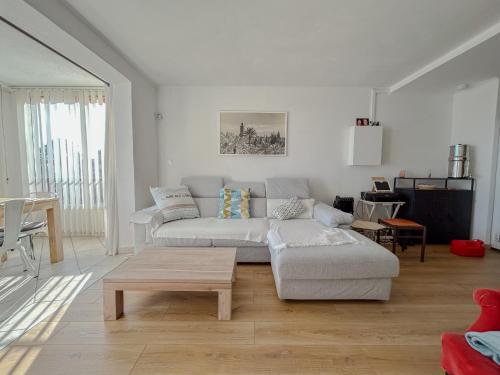 un salon blanc avec un canapé et une table dans l'établissement Vue mer et parking privé, T2 avec accès plage, à Fréjus