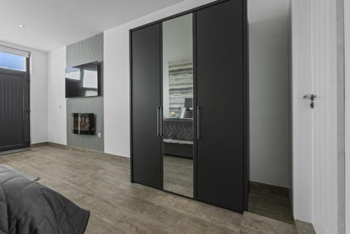 a bedroom with black sliding glass doors with a bed at Stayover Suites in Ballymena