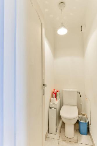 une salle de bain avec des toilettes blanches dans une chambre dans l'établissement 1BR Flat view on Eiffel Tower and Sacré-Coeur, à Paris