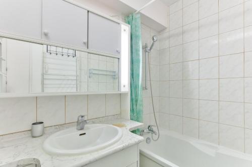 une salle de bain avec un lavabo, une baignoire et un miroir dans l'établissement 1BR Flat view on Eiffel Tower and Sacré-Coeur, à Paris