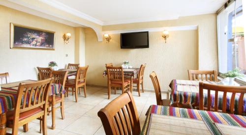 a restaurant with tables and chairs and a flat screen tv at Asitane Life Hotel in Istanbul