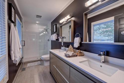 a bathroom with a sink and a toilet and a mirror at Southern Sunrise Covered Dock & Optional Boat Rental in Mooresville
