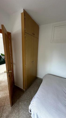 a bedroom with a bed and a wooden cabinet at A primera línea de playa in Playa de Gandia