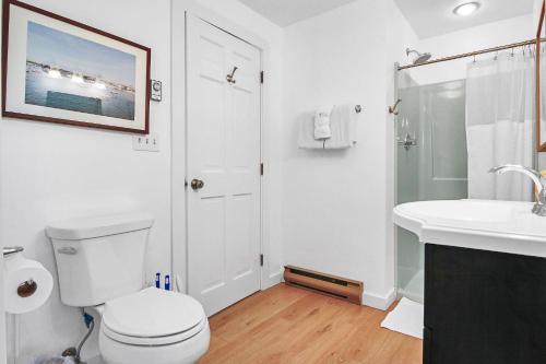 a white bathroom with a toilet and a sink at Charming 3BR Home in Nantucket's Natural Beauty home in Nantucket