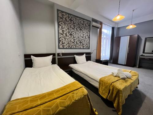 a room with two beds and a table in it at Family Hotel Central in Shumen