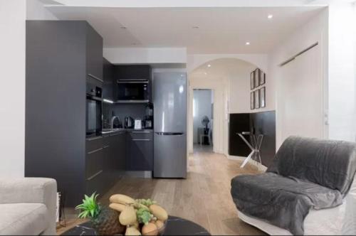 Il dispose d'une cuisine et d'un salon avec un canapé et un réfrigérateur. dans l'établissement Splendide appartement à 2 pas du Martinez, à Cannes
