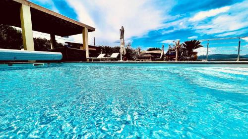 une grande piscine avec de l'eau bleue dans l'établissement luxe 5 étoiles à Porticcio, vue mer, proche des plages, à Porticcio