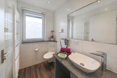 フリードリヒスハーフェンにあるHotel Gästehaus Stock Zimmer Schokotöpfleの洗面台とトイレを備えた白いバスルーム