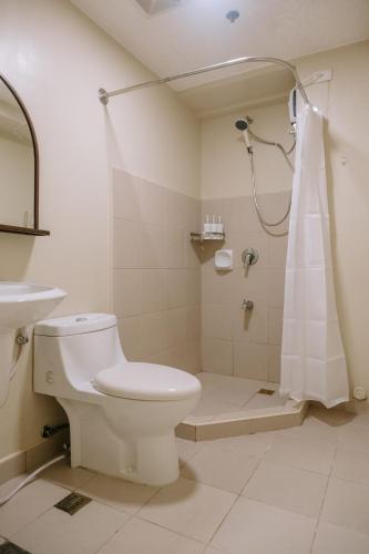 a bathroom with a toilet and a shower at Pool Garden Tranquility in Iloilo City