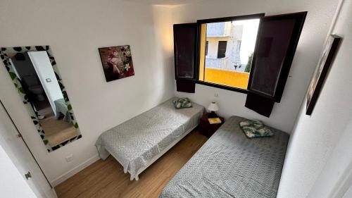 une petite pièce avec un lit et une fenêtre dans l'établissement Porticcio Appartement T2 Résidence Terra Bella 1, proche plage & commerces, à Grosseto-Prugna