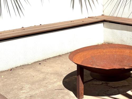 a rusty table sitting in front of a building at The Bowden Hideaway I City Fringe I Sleeps 10 I Free Parking I Walk to Cafe's in Bowden