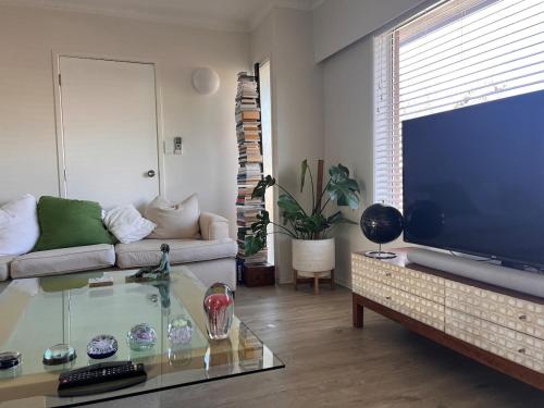 a living room with a couch and a large screen tv at Best on the Block minimum four nights in Auckland