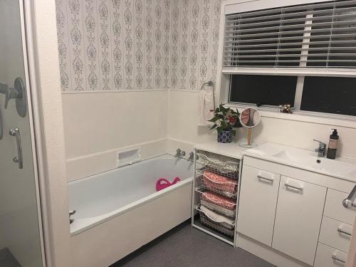 a bathroom with a bath tub and a sink at Best on the Block minimum four nights in Auckland