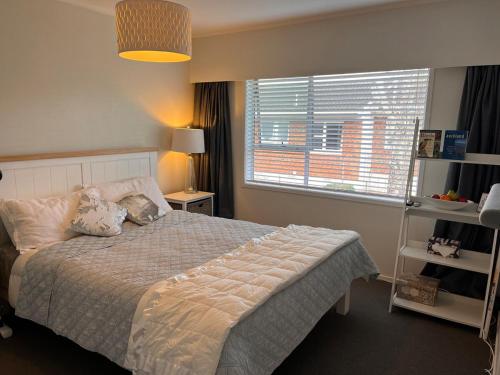 a bedroom with a bed and a large window at Best on the Block minimum four nights in Auckland