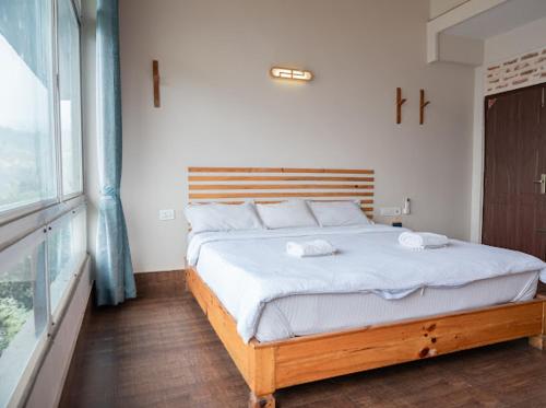 a bedroom with a large bed with white sheets at Hills and Horizon Resort in Benighāt