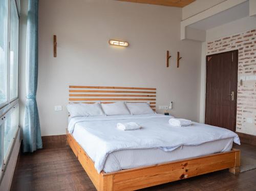a bedroom with a large bed with two towels on it at Hills and Horizon Resort in Benighāt