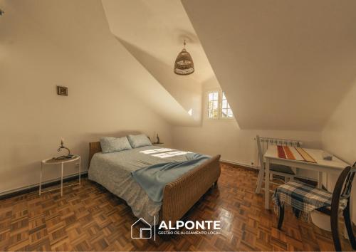 a bedroom with a bed and a desk in it at Casa da Melanie in Caminha