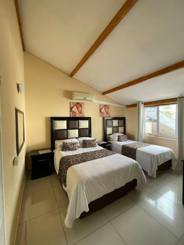 a bedroom with two beds and a large window at Zinzanathi Guest house in Ladysmith