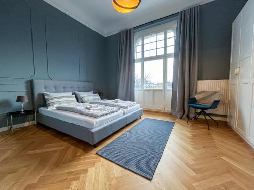 a bedroom with a bed and a blue wall at Wohnperle*GroßerGarten*Villa in Dresden