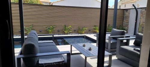un patio avec une table et des chaises et une piscine dans l'établissement Villa Balagan - El Pueblo 7 - Luxe - 6 personnes, au Cap d'Agde