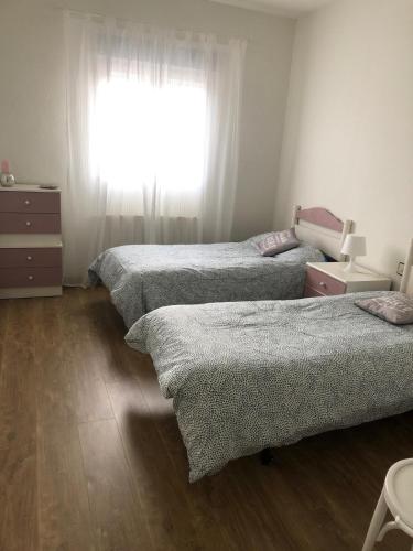 a bedroom with three beds and a window at Casa Mario in El Fresno