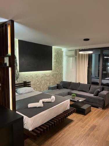 a living room with a large bed and a couch at LiboroPlanet in Niš