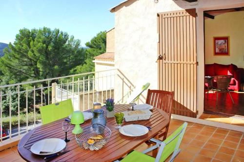 une table et des chaises en bois sur un balcon dans l'établissement Sainte Croix, à Sainte-Croix-de-Verdon