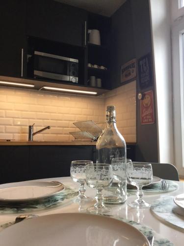 une bouteille de vin posée sur une table avec des verres dans l'établissement Résidence Molière M3, à Soissons