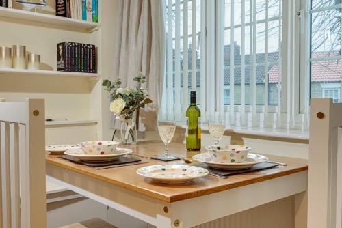 a table with a bottle of wine and glasses at Cosy one bedroom cottage in Pickering in Pickering