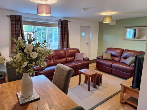 a living room with a couch and a table at Dandelion Cottage - a gorgeous family cottage in Snainton