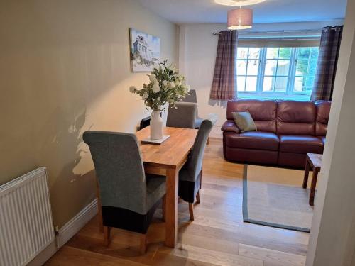 a living room with a wooden table and a couch at Dandelion Cottage - a gorgeous family cottage in Snainton
