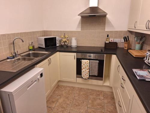 a kitchen with a sink and a stove top oven at Sunflower Cottage - a charming family cottage in Snainton