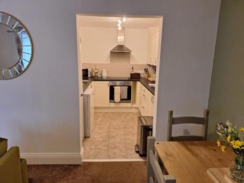 a kitchen and dining room with a table and a clock at Sunflower Cottage - a charming family cottage in Snainton