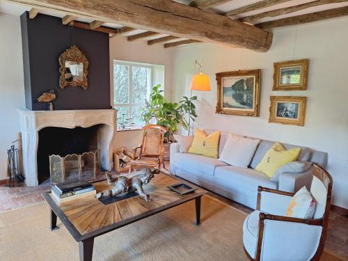 un salon avec un canapé et une table dans l'établissement La Grange de Paul proche de Fontainebleau, à Amponville