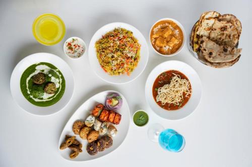a white table with plates of food on it at Clarks Inn Suites Agra Near Tajmahal in Agra